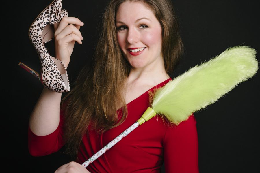 Frau mit Schuh und Staubwedel in der Hand